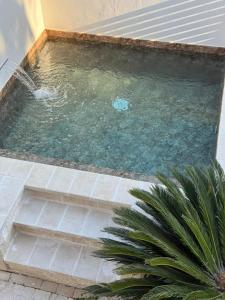 a small pool of water with stairs in a house at Villademar lunarossa in Marzamemi