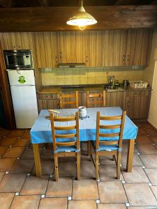 eine Küche mit Tisch und Stühlen und einem Kühlschrank in der Unterkunft Villarrodrigo in Cangas de Onís