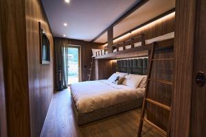 a bedroom with a bunk bed and a ladder at Stella Alpina Chalet in Madonna di Campiglio