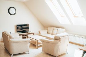 a living room with two chairs and a tv at Rodzinny apartament FOLKER in Węgierska Górka