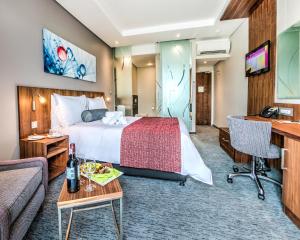 una camera d'albergo con letto e divano di City Lodge Hotel Waterfall City a Midrand