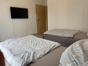 a room with two beds and a flat screen tv at Stilvolles Appartment in Paderborn +4 photos