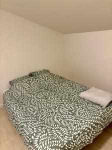 a bedroom with a bed with a black and white comforter at L escapade pro in La Roche-Chalais +3 photos