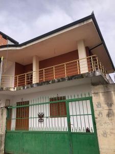 a building with a green door and a balcony at Vila Mehalla in Arape-Rashbulli