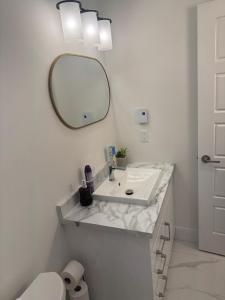 a white bathroom with a sink and a mirror at One bedroom Apt in Riverview in Riverview