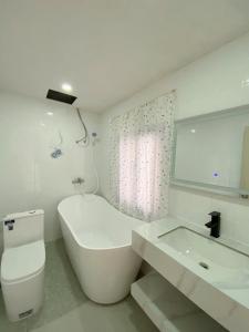 a white bathroom with a toilet and a sink at PAPAYA HOTEL & Café 2 in Ho Chi Minh City