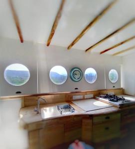 uma cozinha com três janelas redondas e uma pia em Clear Mountain Resort em Kharakvasla