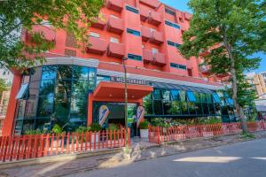 ein orangefarbener Zaun vor einem Gebäude in der Unterkunft Family Hotel Mediterraneo - Azzurro Club in Cesenatico
