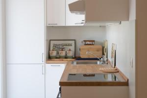 a kitchen with a sink and a white refrigerator at Symphony Tivat Apartment in Donja Lastva