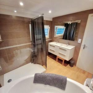 a bathroom with a bath tub and a sink at House for 9 people in Saint-Clair-sur-lʼElle