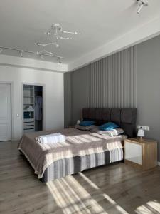a bedroom with a large bed with blue pillows at Centrum Residence apartment in Bishkek