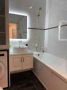 a white bathroom with a sink and a mirror at Centrum Residence apartment in Bishkek +11 photos