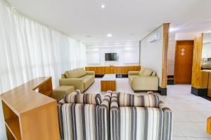 ein Wohnzimmer mit Sofa, Stühlen und einem Tisch in der Unterkunft OZPED Flats Particulares Edifício Premier in Brasilia