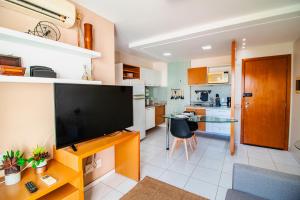 ein Wohnzimmer mit einem Flachbild-TV und eine Küche in der Unterkunft OZPED Flats Particulares Edifício Premier in Brasilia