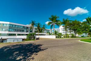 ein großes Gebäude mit Palmen davor in der Unterkunft OZPED Flats Particulares Edifício Premier in Brasilia