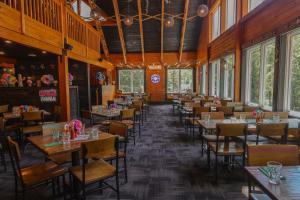 ein Esszimmer mit Tischen, Stühlen und Fenstern in der Unterkunft Camelback Resort in Tannersville