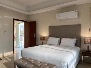 a bedroom with a large white bed and a air conditioner at كورت للشقق المخدومة in Al Khobar