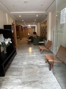 a lobby with chairs and a television in a building at Hôtel Everest, Séjour Balnéaire à Saïdia in Saidia  +12 photos