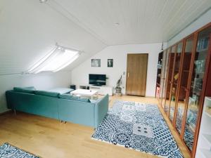 a living room with a blue couch and a tv at Ferienwohnung Merkurpanorama in Gernsbach