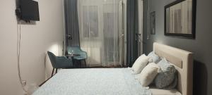 a bedroom with a bed and a chair and a window at Centar Novi Sad in Novi Sad