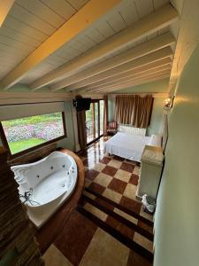a bathroom with a tub and a bed in a room at Los Abetos in Villanueva de la Peña