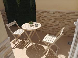 a table and two chairs with a potted plant on it at Hostal Calaya in Corvera