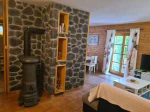 a living room with a stone wall with a wood stove at Apartment Vila Lokve in Lokve