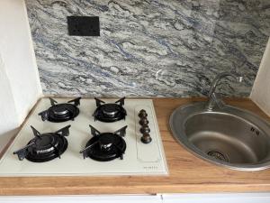 a stove top with a sink next to a counter at Aberdeen Richview Luxury Apartments- Entire One Bedroom Apartment D201 in Freetown +19 photos