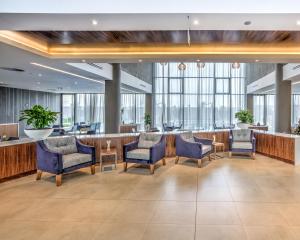 a lobby with chairs and a bar with windows at City Lodge Hotel Waterfall City in Midrand