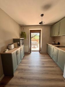 a kitchen with green cabinets and a wooden floor at El Refugio de los Corrales in San Mateo