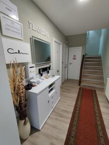 a living room with a large television and a staircase at Travesia Rooms in Sarria
