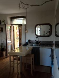 a kitchen with a table and a sink and a mirror at Botanica Calcata in Calcata