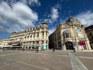 a large building with a clock tower in a street at T2 centre historique écusson in Montpellier
