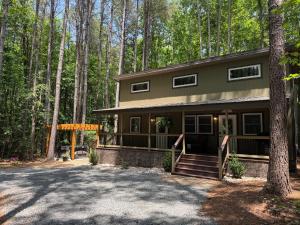 a house in the woods with a driveway at Pine Cone Cottage in Hamptonville