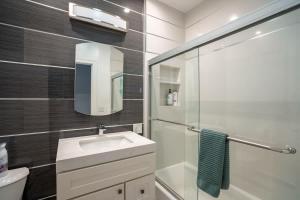 オークランドにあるOak Manor - Chic & Stylish 2BR Apartment Retreatの洗面台と鏡のあるバスルーム