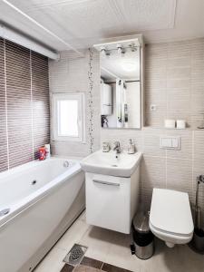 a bathroom with a tub and a sink and a toilet at The Serene Oasis Red in Sarajevo
