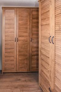 a wooden closet with wooden doors in a room at The Serene Oasis Red in Sarajevo