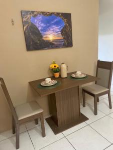 a wooden table with two plates and two chairs at Apartamento completo e central! CASA DUNAS! in Fortaleza