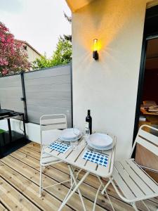 una mesa y sillas en un patio con una botella de vino en Stylish Garden Escape- BBQ, Projector & Exclusive Parking, en Cagnes-sur-Mer