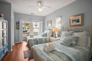 a bedroom with two beds and a ceiling fan at 38 Davis Love in Fripp Island +35 photos