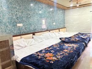 a bed in a room with a blue wall at Hotel Shree dhan Laxmi palace in Jāmb
