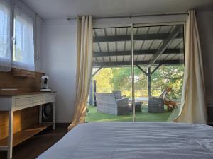 a bedroom with a bed and a large glass window at La Terrasse in Argenton lʼÉglise