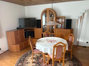 a dining room with a table and chairs and a tv at Naturblick am Dorfausgang in Rheinau