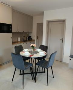 a dining room with a table and chairs in a kitchen at Willa Róż in Rusinowo