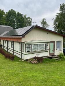 a small white house with a solar roof at Valterkrasti in Ogureckaja
