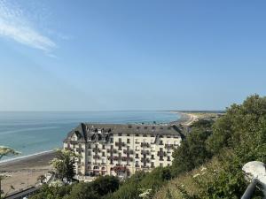 a building on a hill next to a beach at T2 avec balcon à 5 mn à pied de la mer in Donville-les-Bains