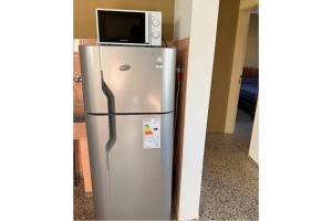 コスキンにあるCasa en Cosquínの銀色の冷蔵庫とその上に電子レンジ