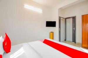a bedroom with a red and white bed and a television at Hotel O Amar Raj Stay in Kolkata