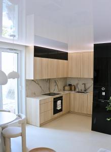 kuchnia z drewnianymi szafkami i stołem oraz jadalnia w obiekcie Centaurus Olsztyn Sunset Apartament - Dwa Balkony & Darmowy Parking podziemny & Stare Miasto & Galeria & Widok & Planetarium & Centrum miasta w Olsztynie