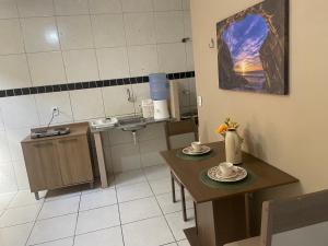 a small kitchen with two tables and chairs and a table with cups at Apartamento completo e central! CASA DUNAS! in Fortaleza +8 photos